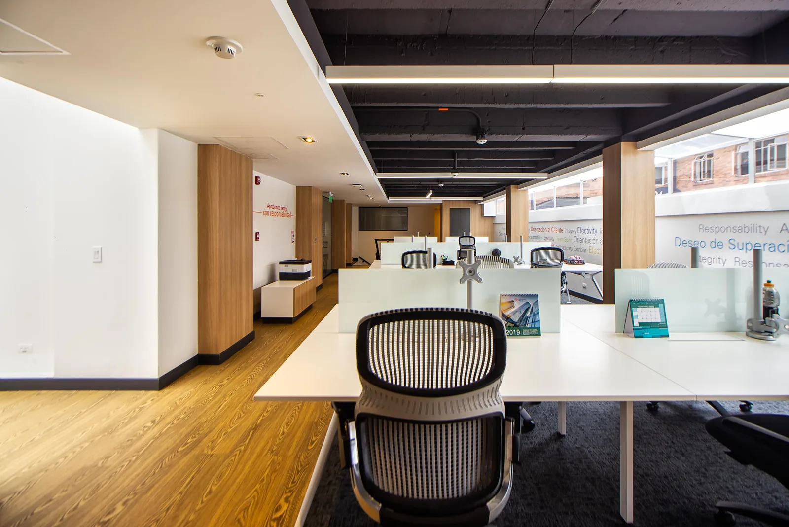 Polished office with white desks and wood ceiling